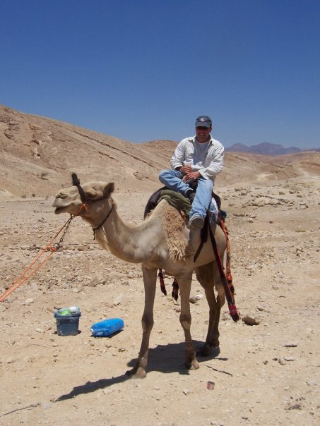 An archaeologist on a camel in the desert
