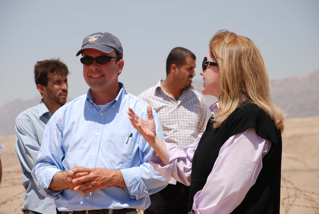 A group of archaeologists in a desertous landscape talking